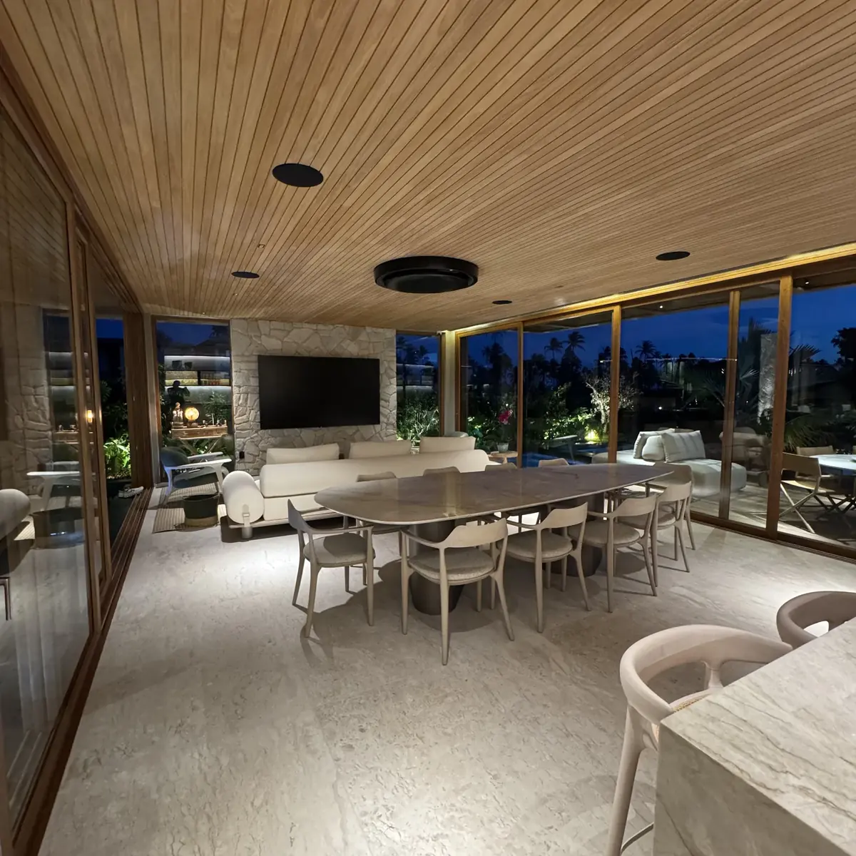 Varanda gourmet integrada com TV e iluminação automatizada
