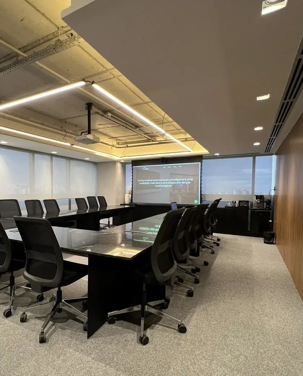 Sala de reunião com projetor, tela e iluminação